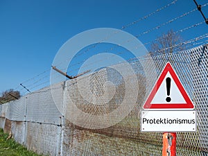 Border fence with warning sign protectionism in German