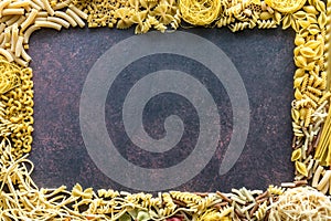A border frame of dried pasta with copy space in the middle.