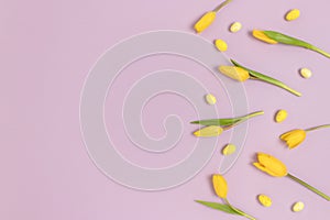 Border frame made of flowers and easter eggs on a purple pastel background