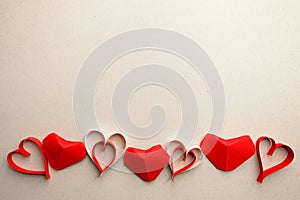 Border frame from red origami paper hearts on gray background. Valentine`s Day absctract. Symbol of love. Copy space, flat lay