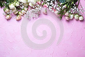 Border from fresh white gypsofila and white rose flowers on  pink textured background photo