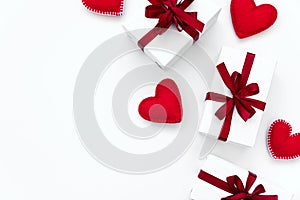 Border from gift boxes wrapped red ribbon with felt hearts on white background. Valentines day or Womans day holidays concept. Top