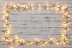 A border of golden star christmas lights, on a destressed woodern background