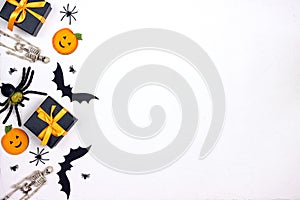 Border from Halloween holiday decorations and gifts on white background