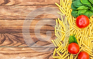 Border from ingredients for cooking pasta on wooden background. Top view. Space for text