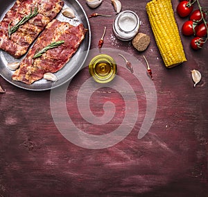 Border Ingredients for cooking raw Meat with bones for soup or broth with with herbs, cherry tomatoes, oil, corn, spices on wooden