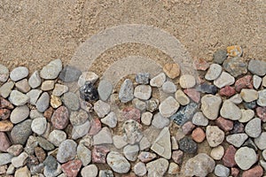 Border made of pebble stones on sand