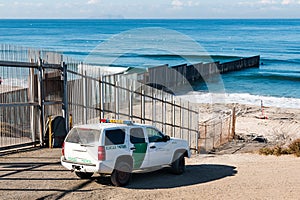 Border Patrol Vehicle Near U.S./Mexico Border Wall at Pacific Ocean