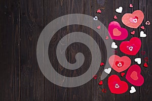 Border of Red paper hearts on wooden background.