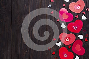 Border of Red paper hearts on wooden background.