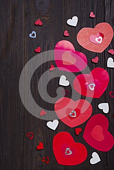 Border of Red paper hearts on wooden background.