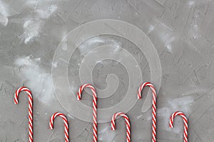 Border of red and white candy canes on grey background. Christmas concert