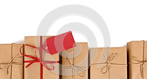 Border row of brown paper parcels, one unique with red ribbon bow and gift tag