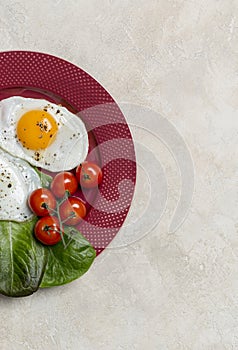 Border with two fried eggs breakfast with vegetables at plate. Horizontal free space