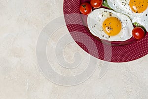 Border with two fried eggs breakfast with vegetables at plate. Horizontal free space