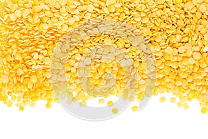 Border of yellow purified lentil closeup with copy space on white background.