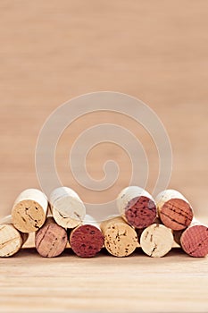 Borders of wine corks on blurred wooden background. Vertical format.