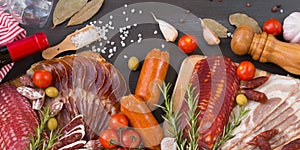 Bordure of different spanish embutidos, like fuet, jamon, chorizo, bacon and lomo embuchado with red wine, olives and spice.