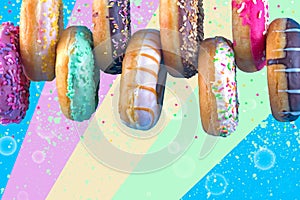 Bordure of sweet doughnuts with different kinds of topping on colorful background.
