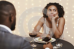 Bored afro woman attending first date at restaurant