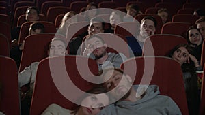 Bored audience watching film in cinema. Spectators fall asleep from boring film