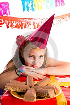 Bored blond kid girl in party with chocolates