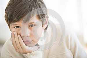 Bored Boy With Hand On Chin At Home