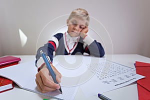 Bored boy writing in notebook