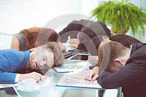 Bored business people sleeping in a meeting colleague.