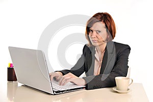 Bored business red haired woman in stress at work with laptop