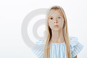 Bored and carefree little girl trying to cheer up, fooling around. Portrait of playful adorable young female child with