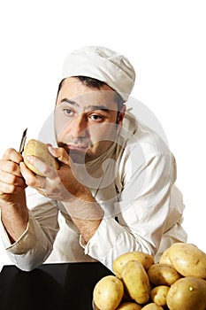 Bored chef peeling potatoes