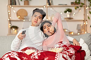 Bored Chinese Couple Watching TV Yawning Celebrating Christmas At Home