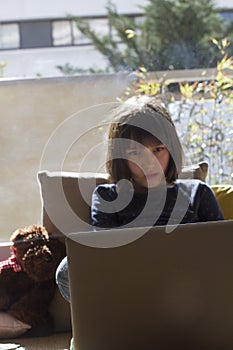 Bored city child hypnotized by computer for lockdown homeschool learning photo