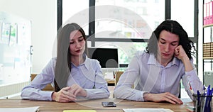 Bored couple of office workers waits for important call