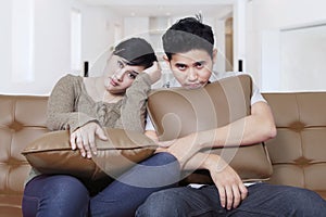 Bored couple sit on a couch