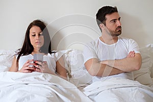 Bored couple and worried man by his wife internet addiction