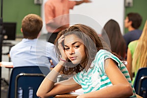 Bored Female Teenage Pupil In Classroom