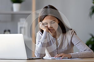 Bored funny woman resting on hand sleeping at workplace