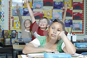Bored Girl With Classmates Raising Hands In Background photo