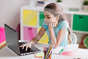 Bored girl with laptop and notebook at home