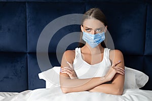 Bored Girl In Medical Mask Sitting Crossing Hands In Bed