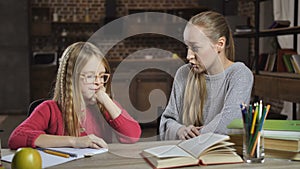 Bored girl unwilling to do homework with mother