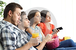 Bored group of friends watching tv at home