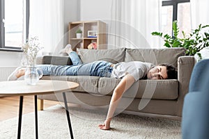 Bored or lazy young woman lying on sofa at home