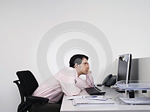 Bored Male Office Worker At Desk