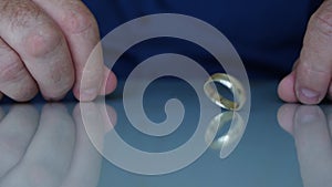 A Bored Man Playing with His Wedding Ring on the Table, a Symbol of Marriage