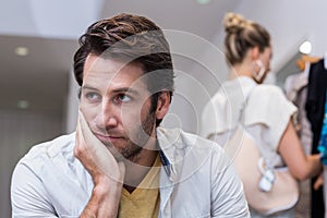 Bored man sitting in front of his girlfriend photo