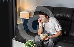 Bored man watching TV on sofa at night