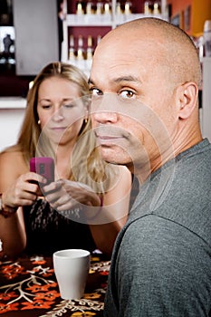 Bored man with woman on cell phone